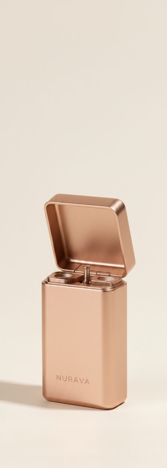 Rose gold rectangular stainless steel Nurava floss case, hinged lid open, photographed on a warm off-white background